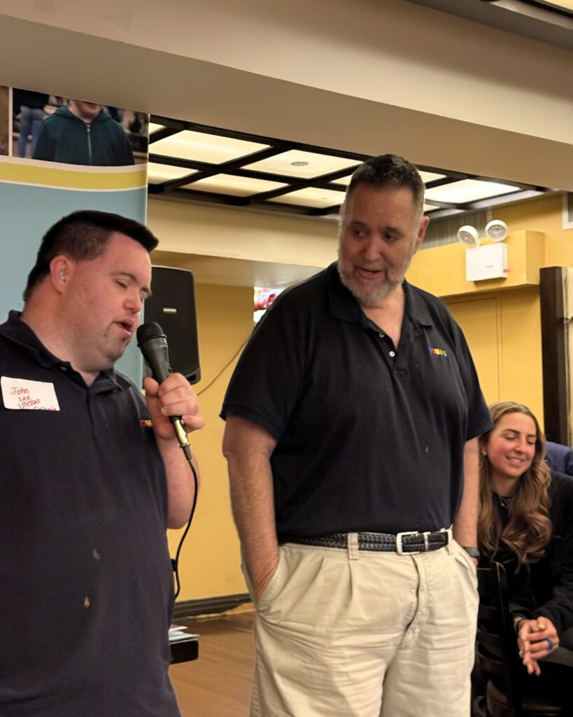 john with a microphone and Mark standing next to him watching